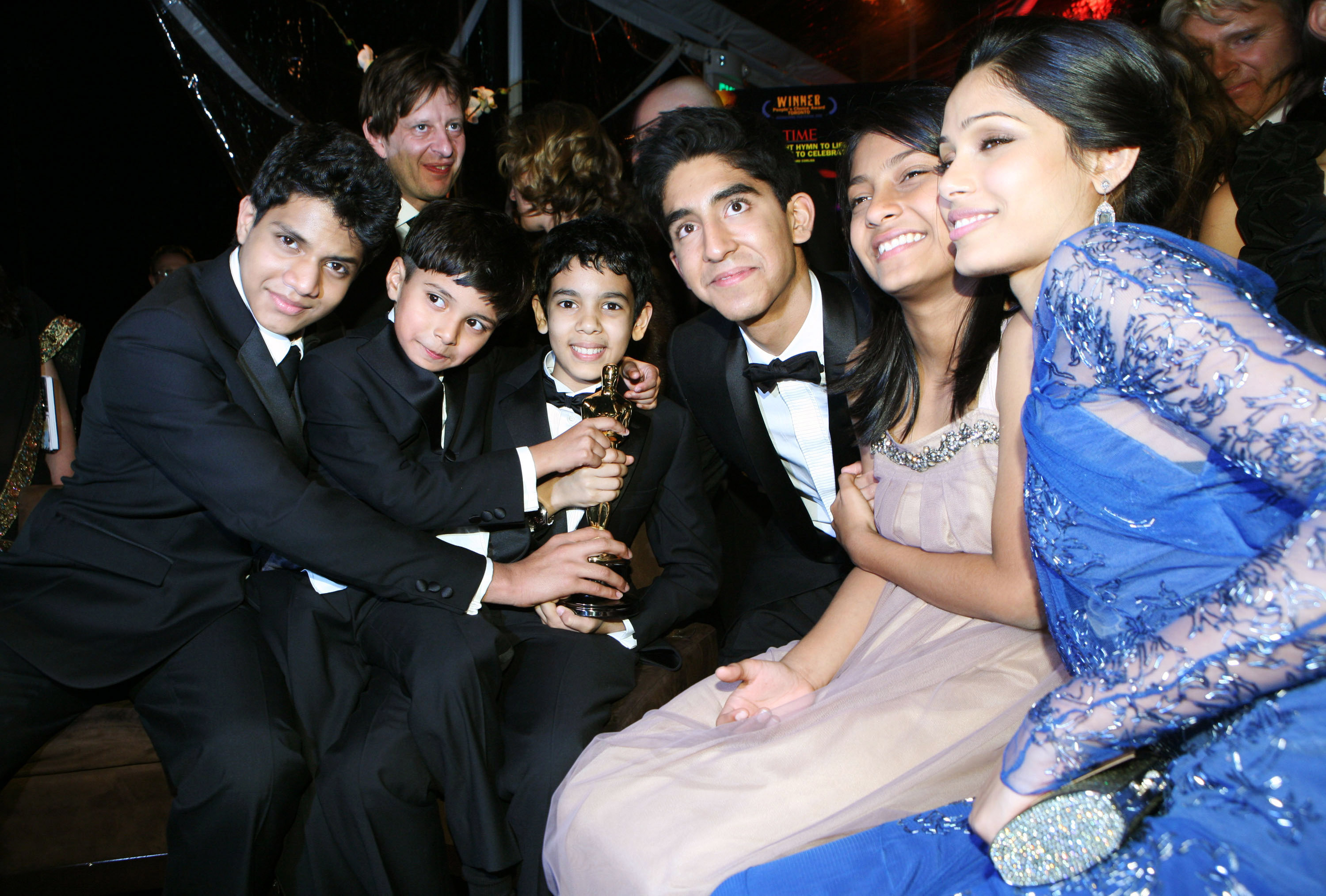 Group of &quot;Slumdog Millionaire&quot; cast members posing with an award at a formal event