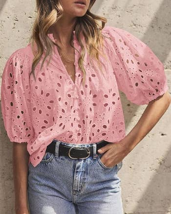 Close-up of a model wearing a pink eyelet blouse