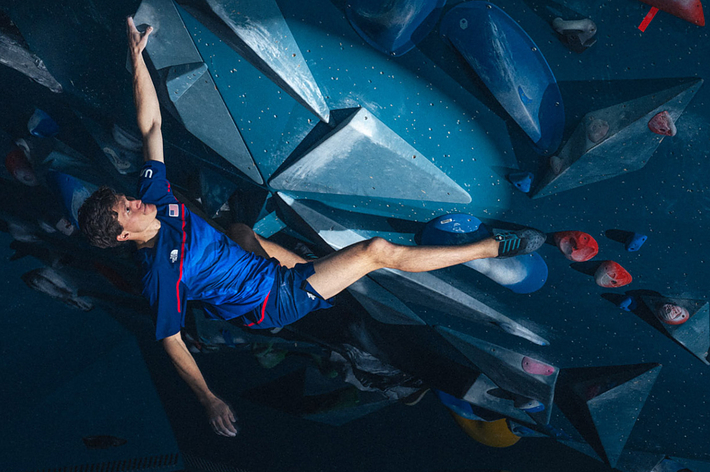 Person in athletic wear rock climbing on an indoor climbing wall