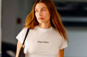 Woman in a white shirt with text "Nepo Baby" walking