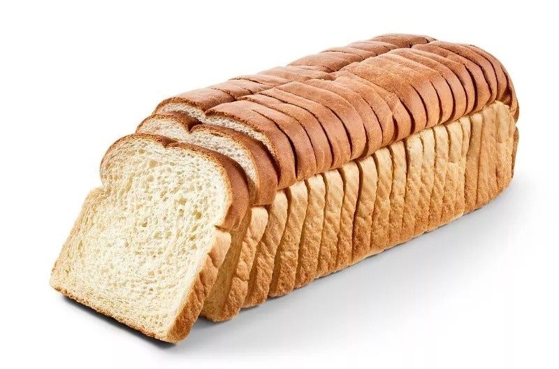A loaf of sliced white bread on a white background