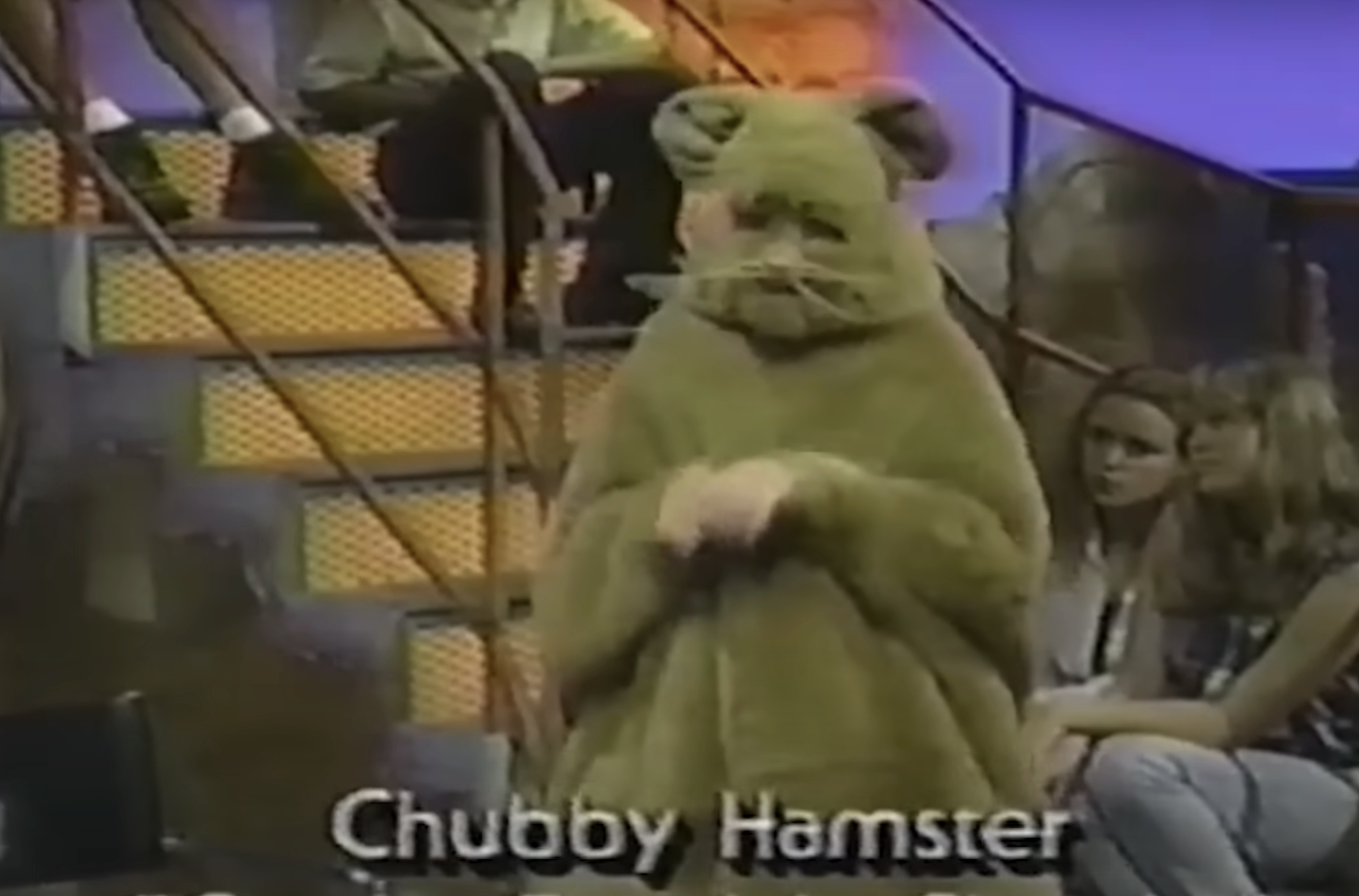 Ryan in a hamster costume on a TV show set with onlooking audience