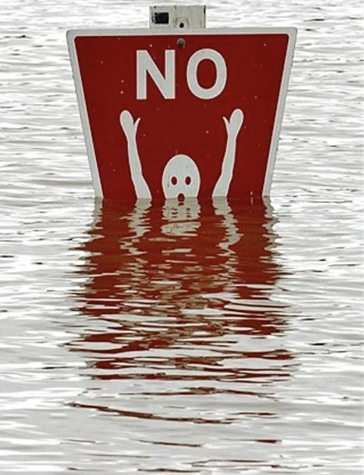 Sign with &quot;NO&quot; above a skull and two hands raised above water, indicating danger or no swimming