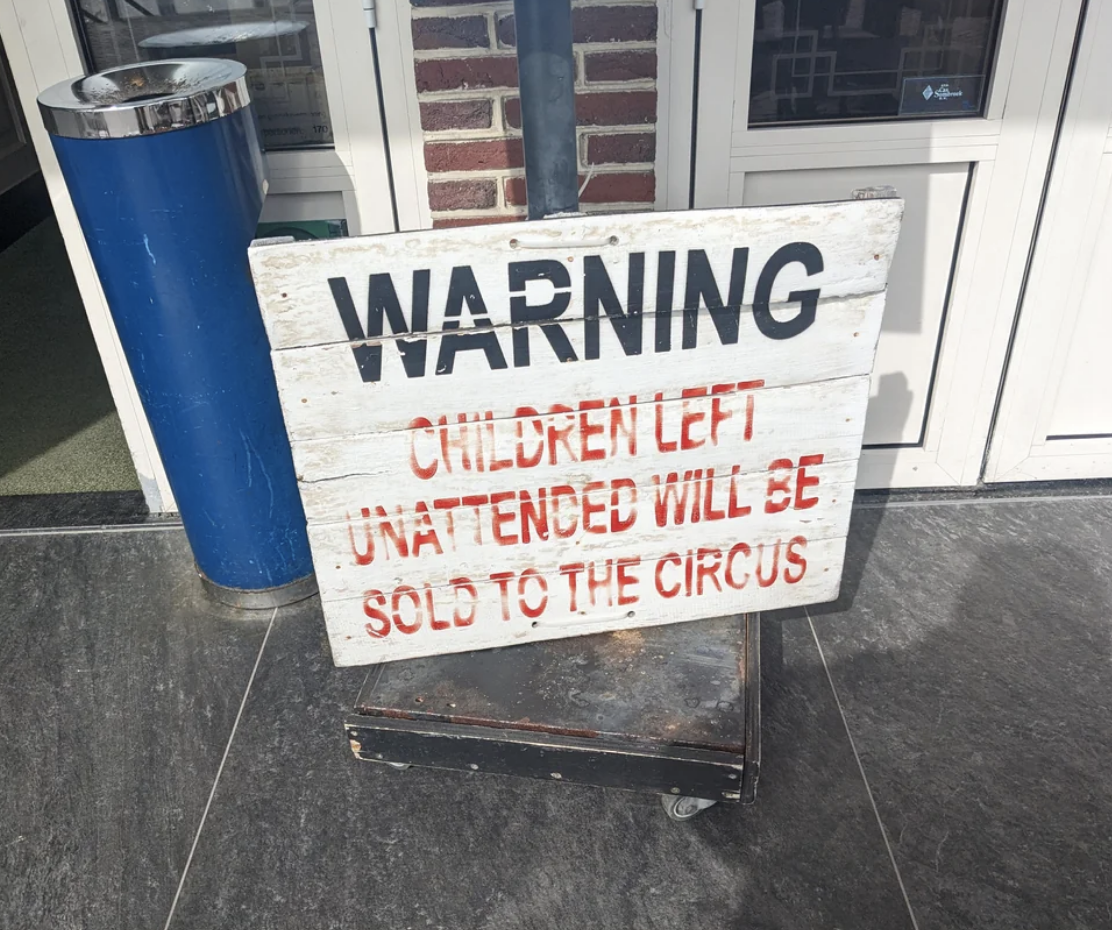 Humorous warning sign stating unattended children will be sold to the circus