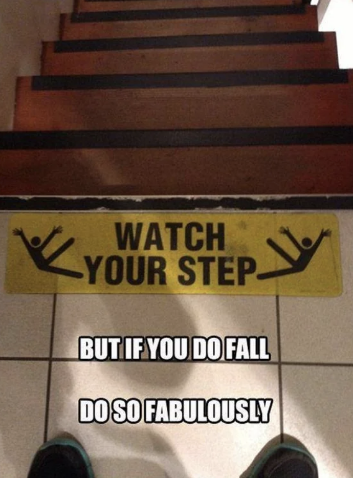 Caution sign on stairs with humorous message about falling fabulously