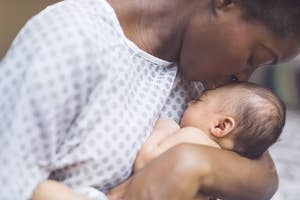Woman kisses her baby's forehead as they cuddle closely