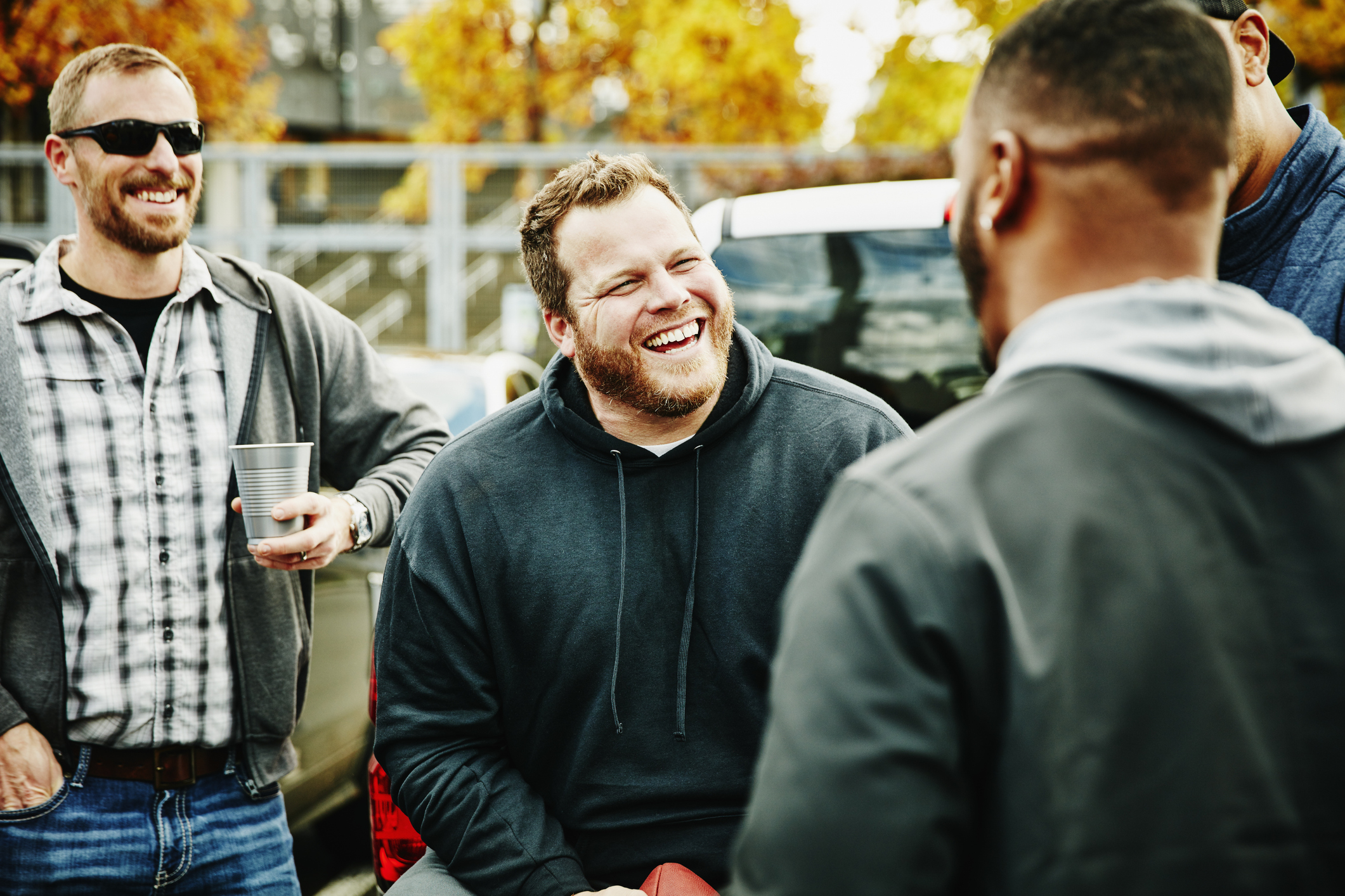 Group of friends laughing and socializing outdoors at a casual gathering
