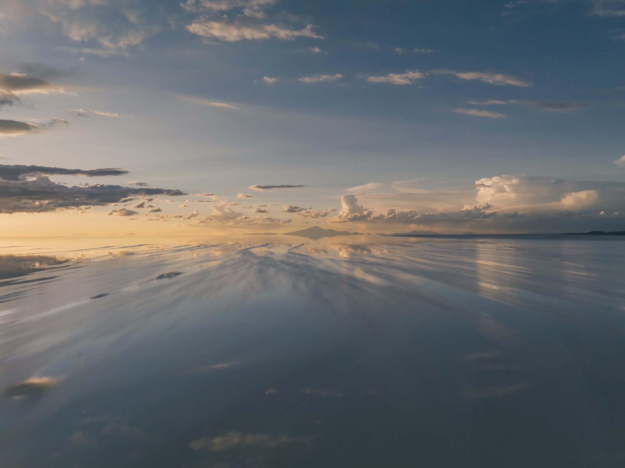 Cloudy sky reflected on a calm water surface at dusk
