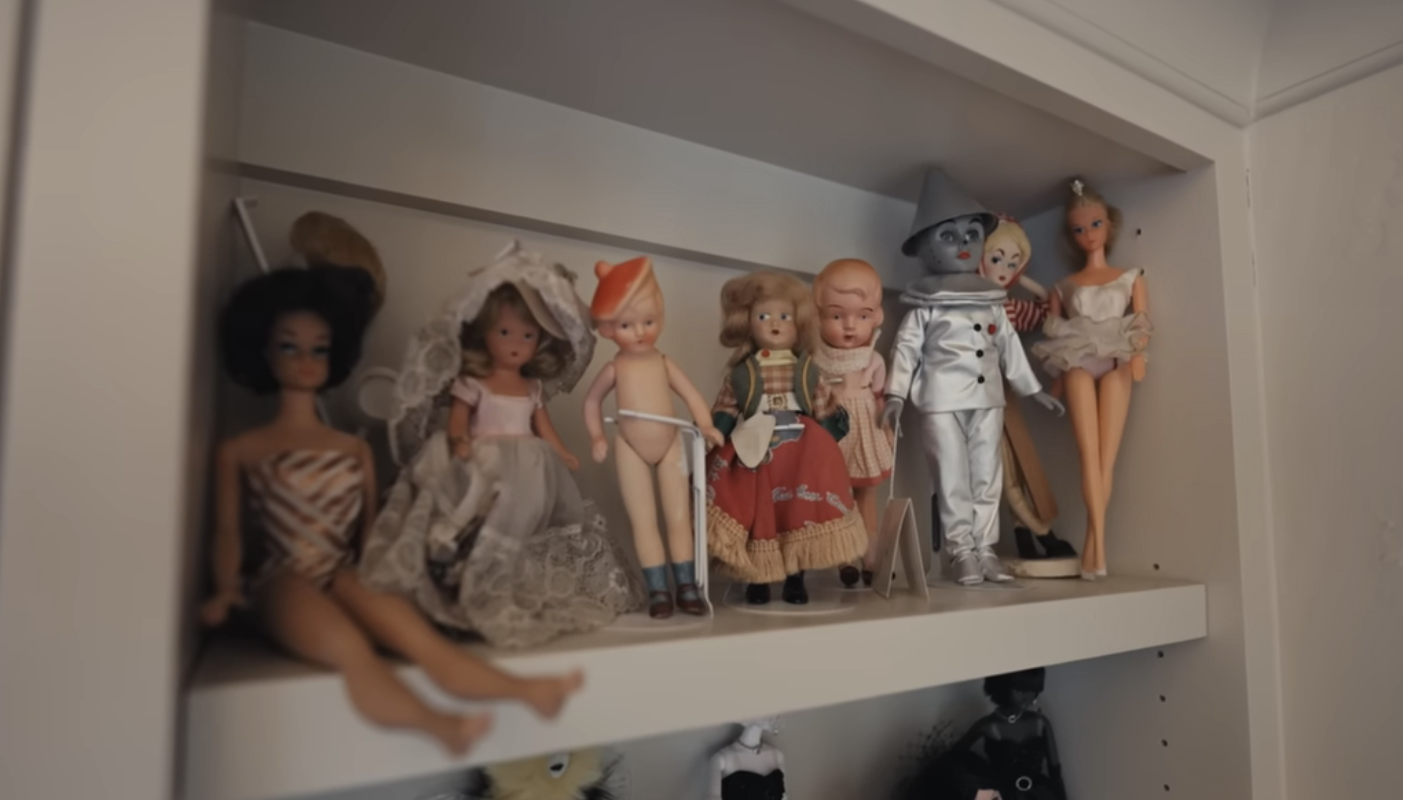A collection of vintage dolls displayed on a shelf