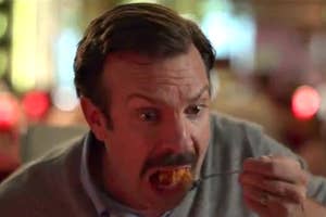Ted Lasso eating Indian food with a pained expression.