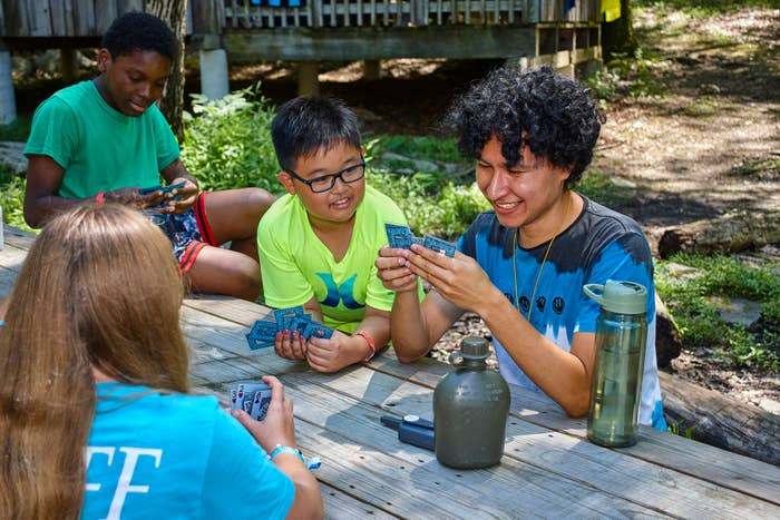 Group of children engaged in a card game at an outdoor table