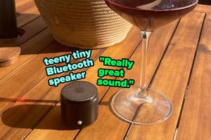 Very small Bluetooth speaker next to a wine glass, captioned with positive sound review