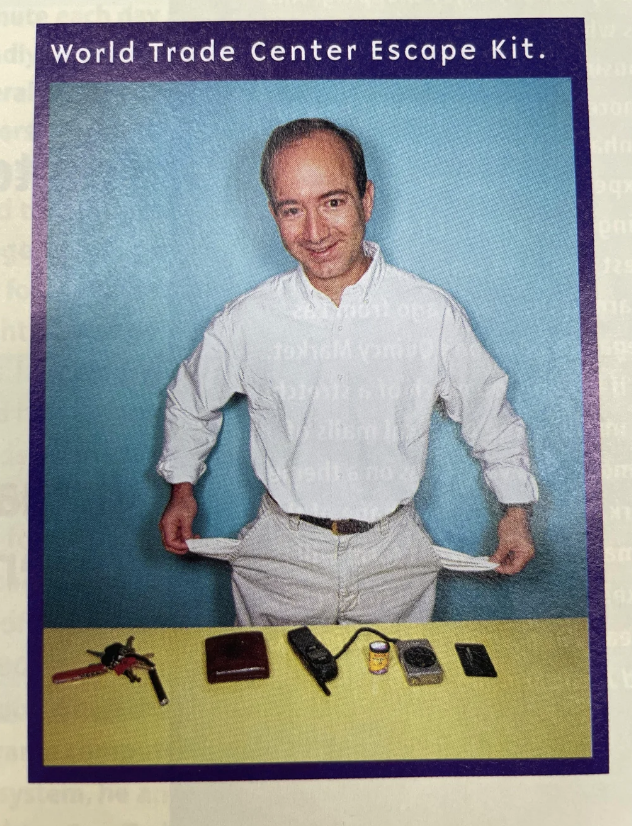 Man in white shirt displaying survival items labeled &quot;World Trade Center Escape Kit.&quot;