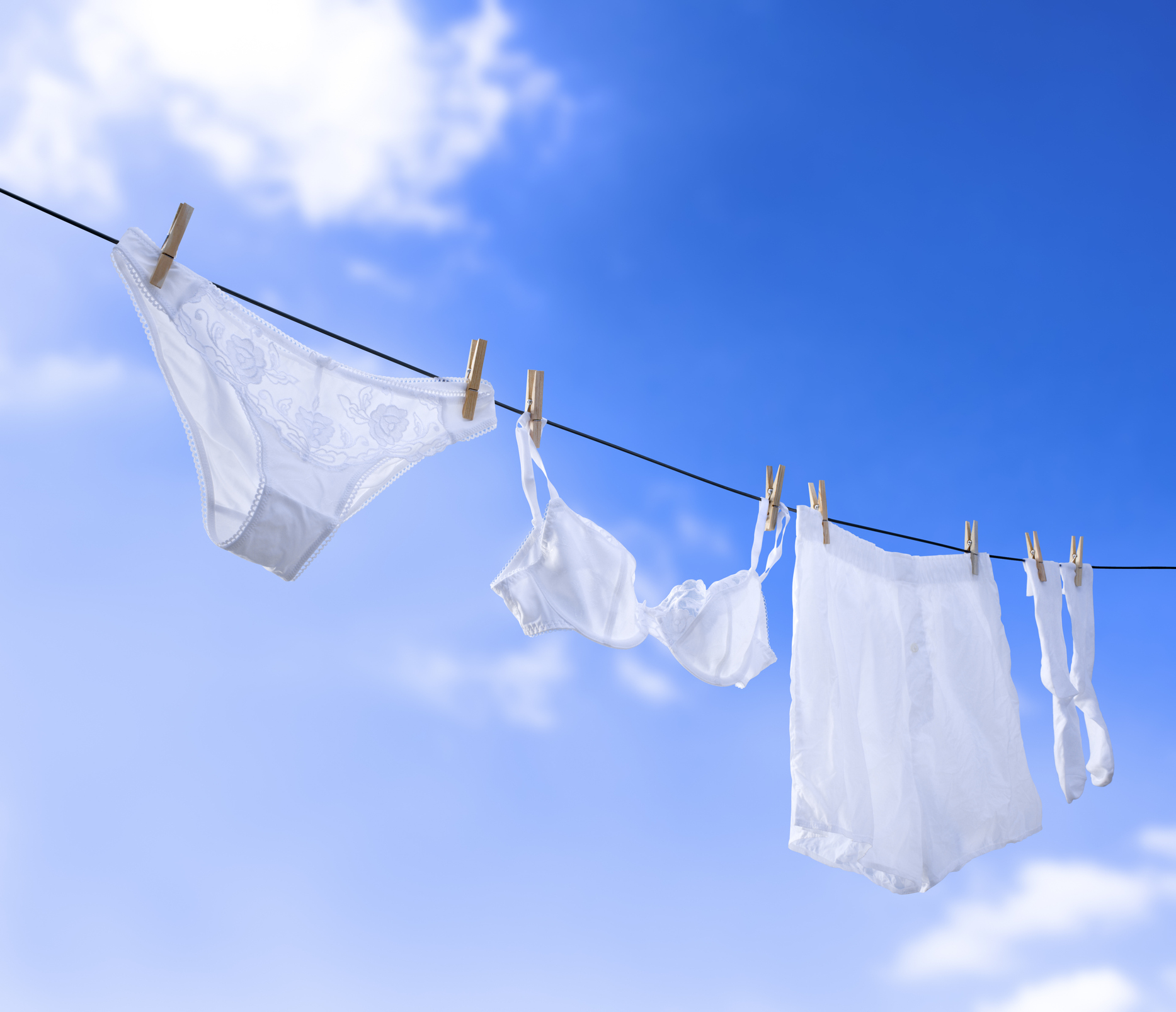 White underwear hanging on a clothesline against a sky background