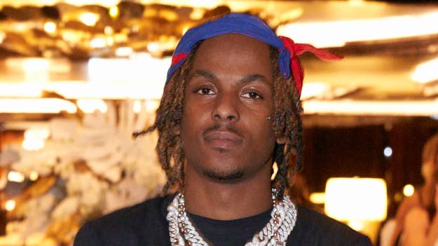 Music artist poses with red headband and layered necklaces