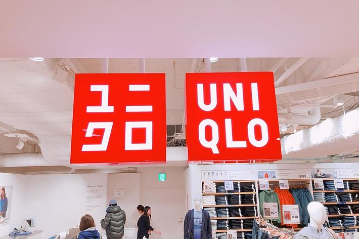 ユニクロの店内。正面に「ユニクロ」と書かれた看板があり、商品が並べられている。