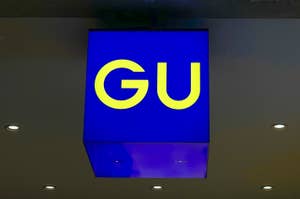 Store signage with the letters "GU" in bold, hung from ceiling, no people visible