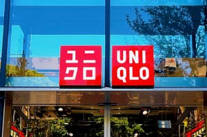 Storefront of UNIQLO with brand logos and reflective glass facade