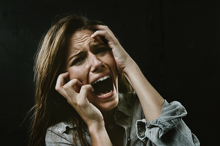 悲鳴を上げて頭を抱える女性