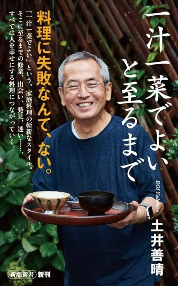 画像には笑顔の中年男性がお茶碗と急須を持っています。背景には緑の植物。