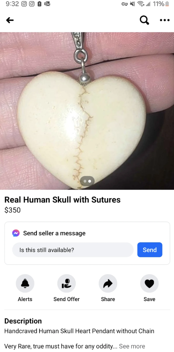 Hand holding a heart-shaped pendant resembling a human skull with sutures, listed for sale online