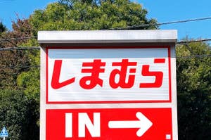 Red and white sign with Japanese text and "IN" indicating an entrance to the right