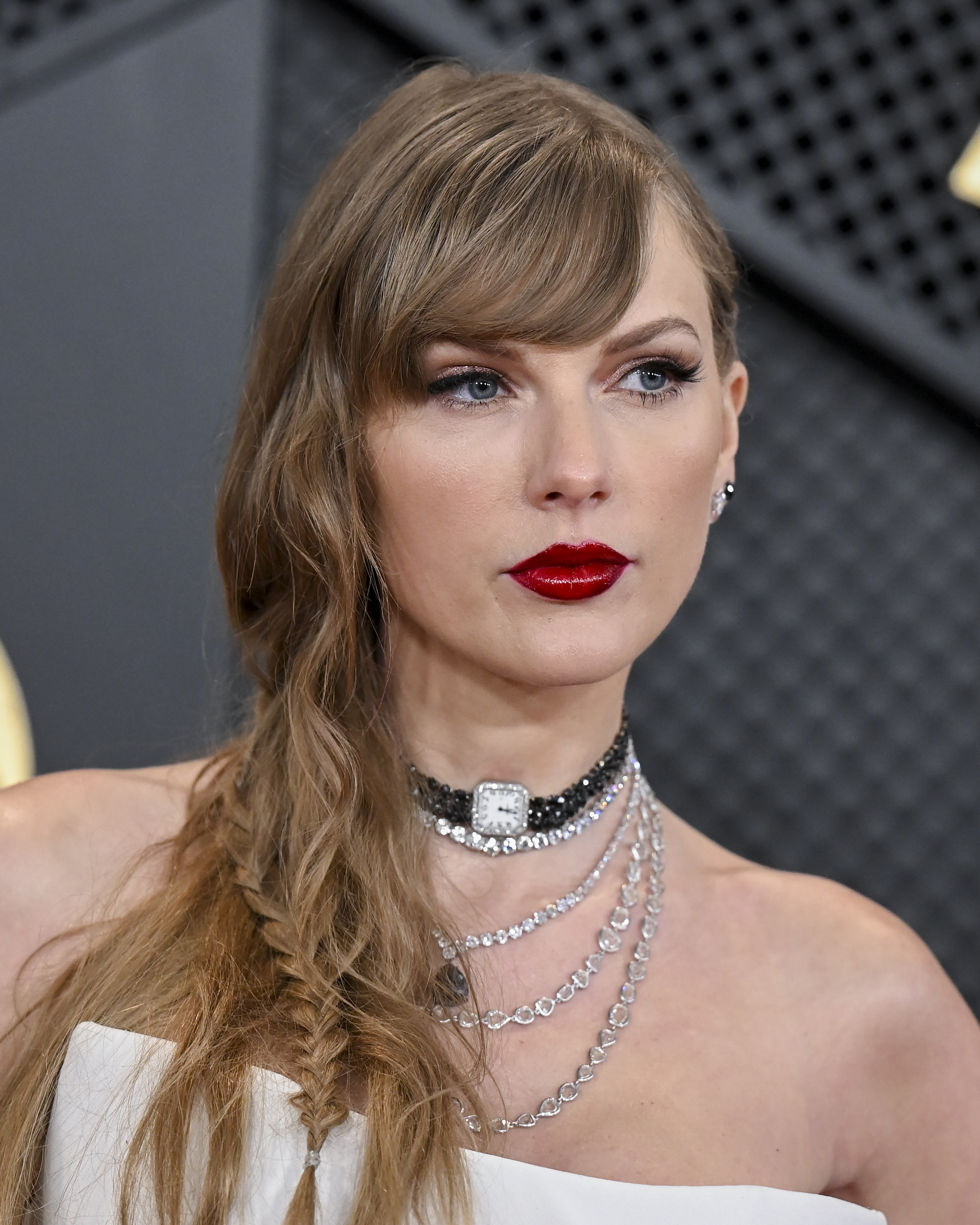 Taylor Swift at an event wearing a strapless dress with a bejeweled choker and red lipstick