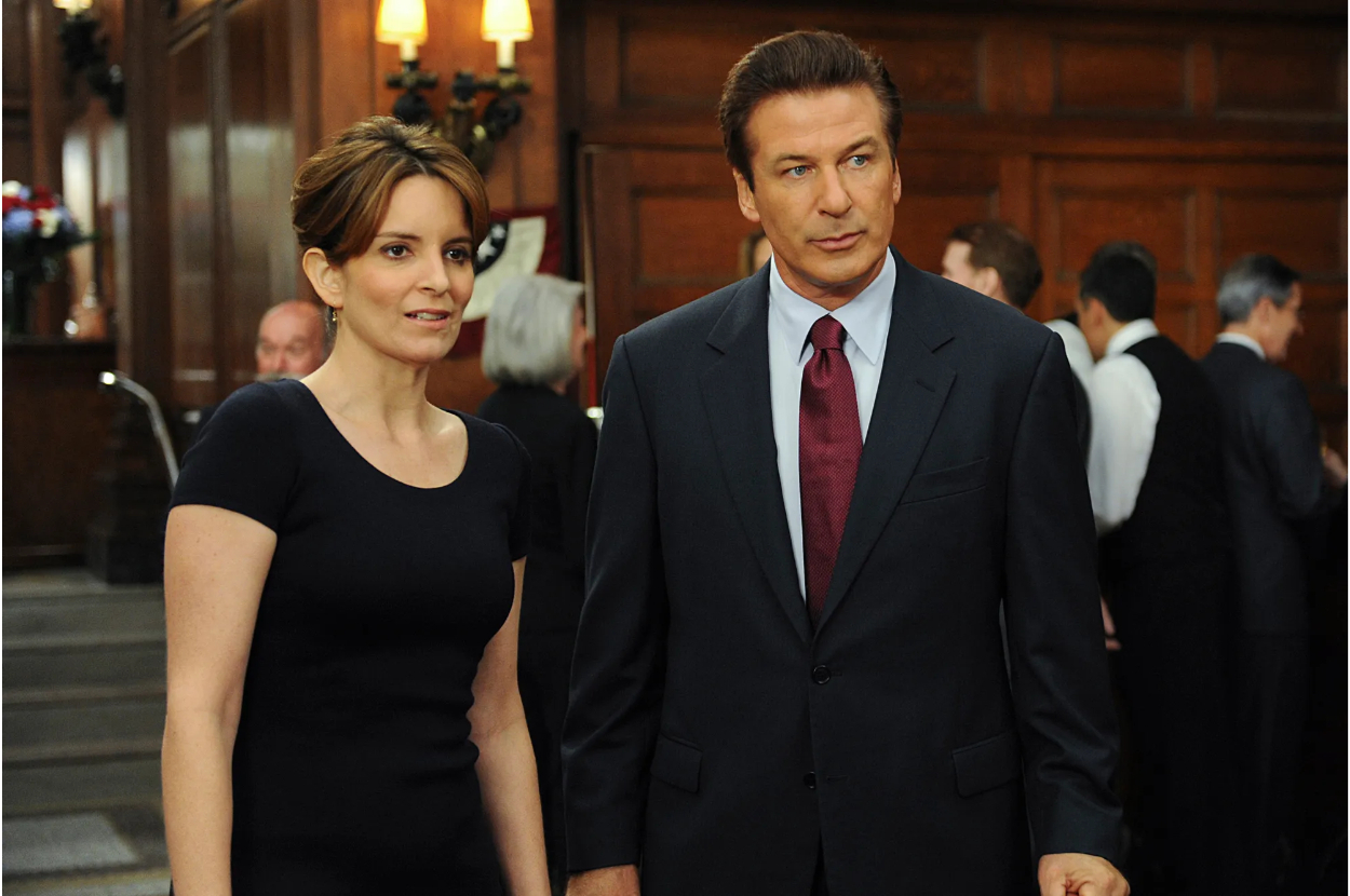 Tina Fey and Alec Baldwin in a scene from the TV show, dressed in business attire