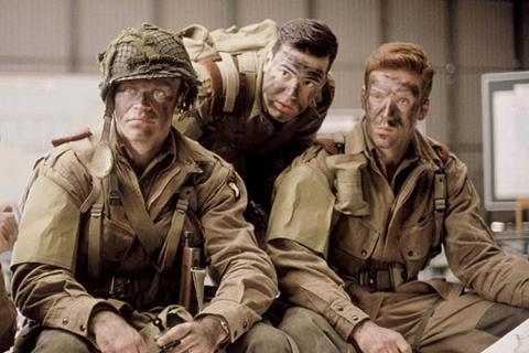 Three actors in military uniforms portraying soldiers in a scene from a war-based TV or movie production