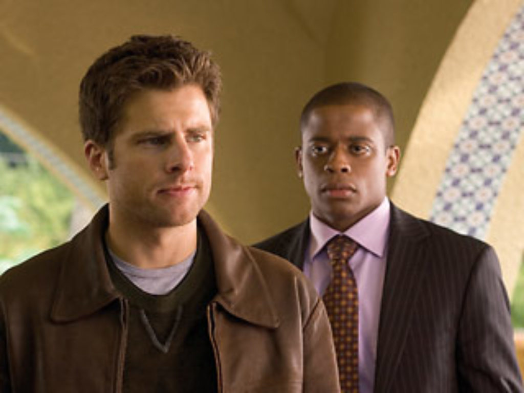 Two characters from a TV show, one in a leather jacket, the other in a suit, looking serious