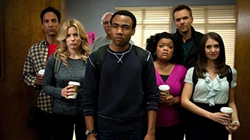 Cast of &quot;Community&quot; standing together, facing forward, with various expressions, holding coffee cups