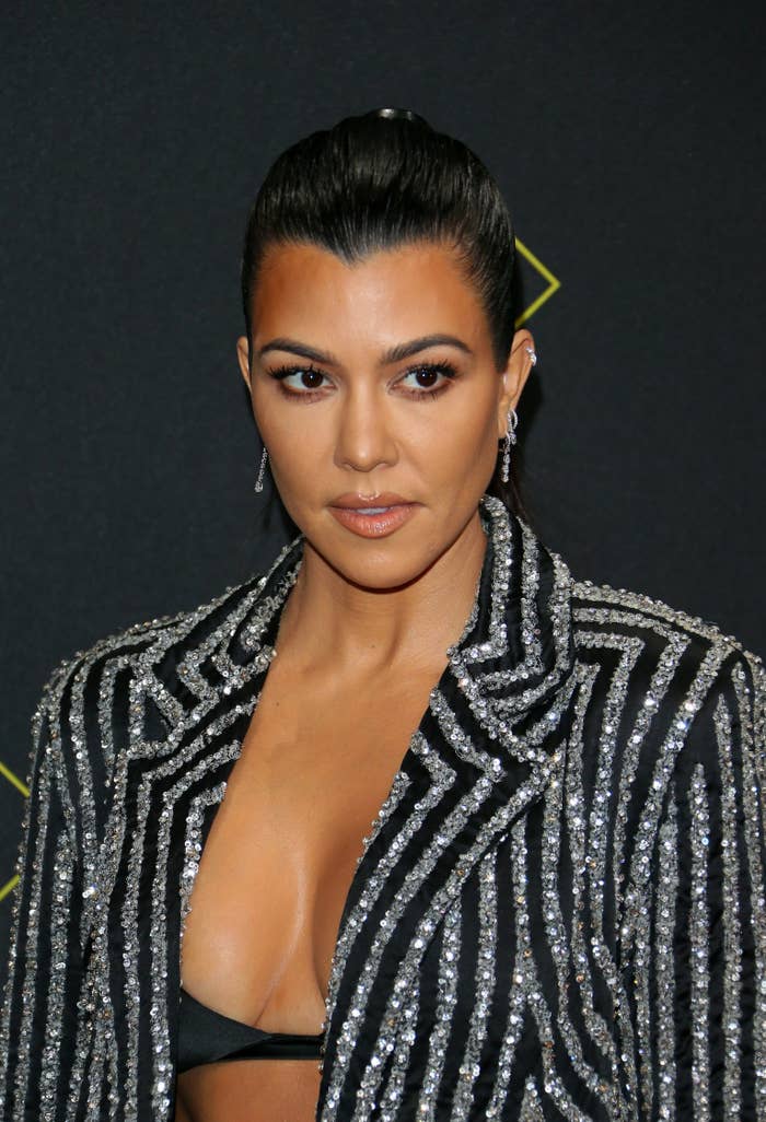 Kourtney Kardashian wearing a glittering blazer with bra top on the red carpet