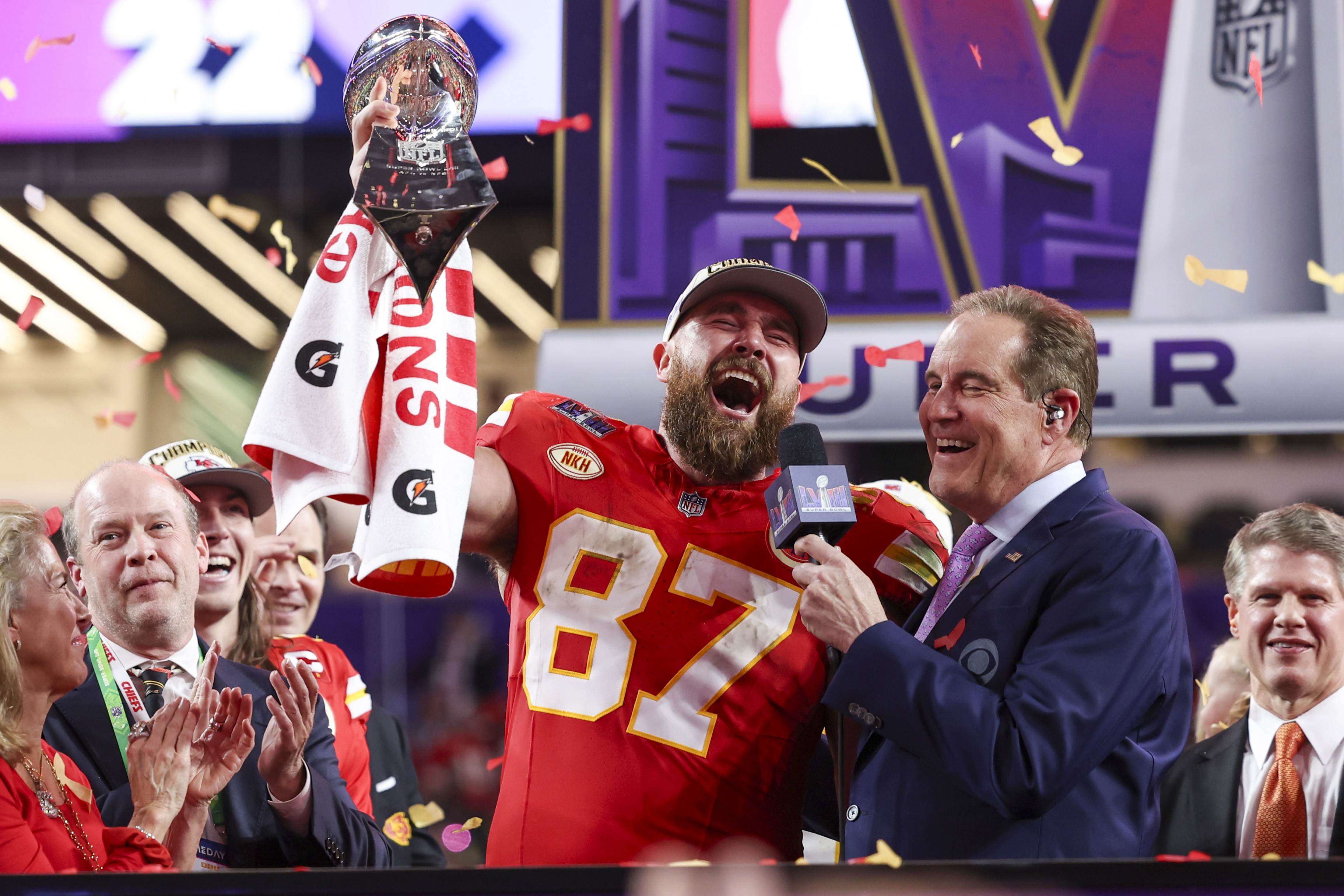 Travis Kelce holding up the Super Bowl trophy