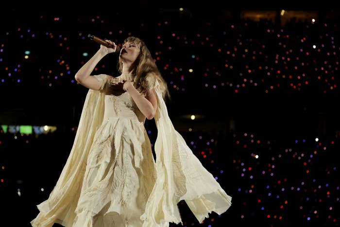 Taylor singing on stage wearing a flowing dress