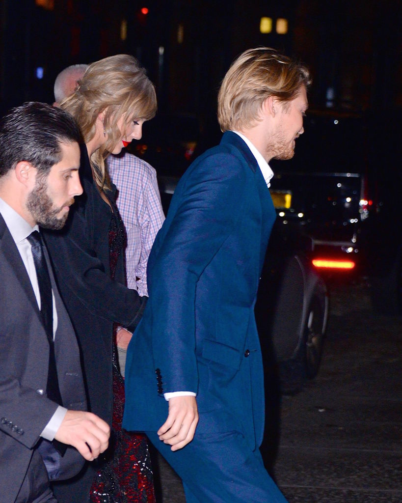 Taylor and Joe walking, both facing away with bodyguards nearby