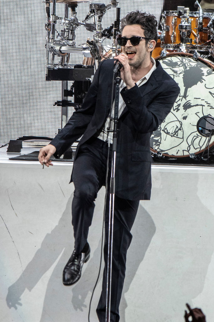 Matty performing on stage in a suit