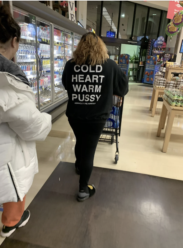 Person in supermarket with sweater featuring bold text. Text inappropriate for a parenting-focused article