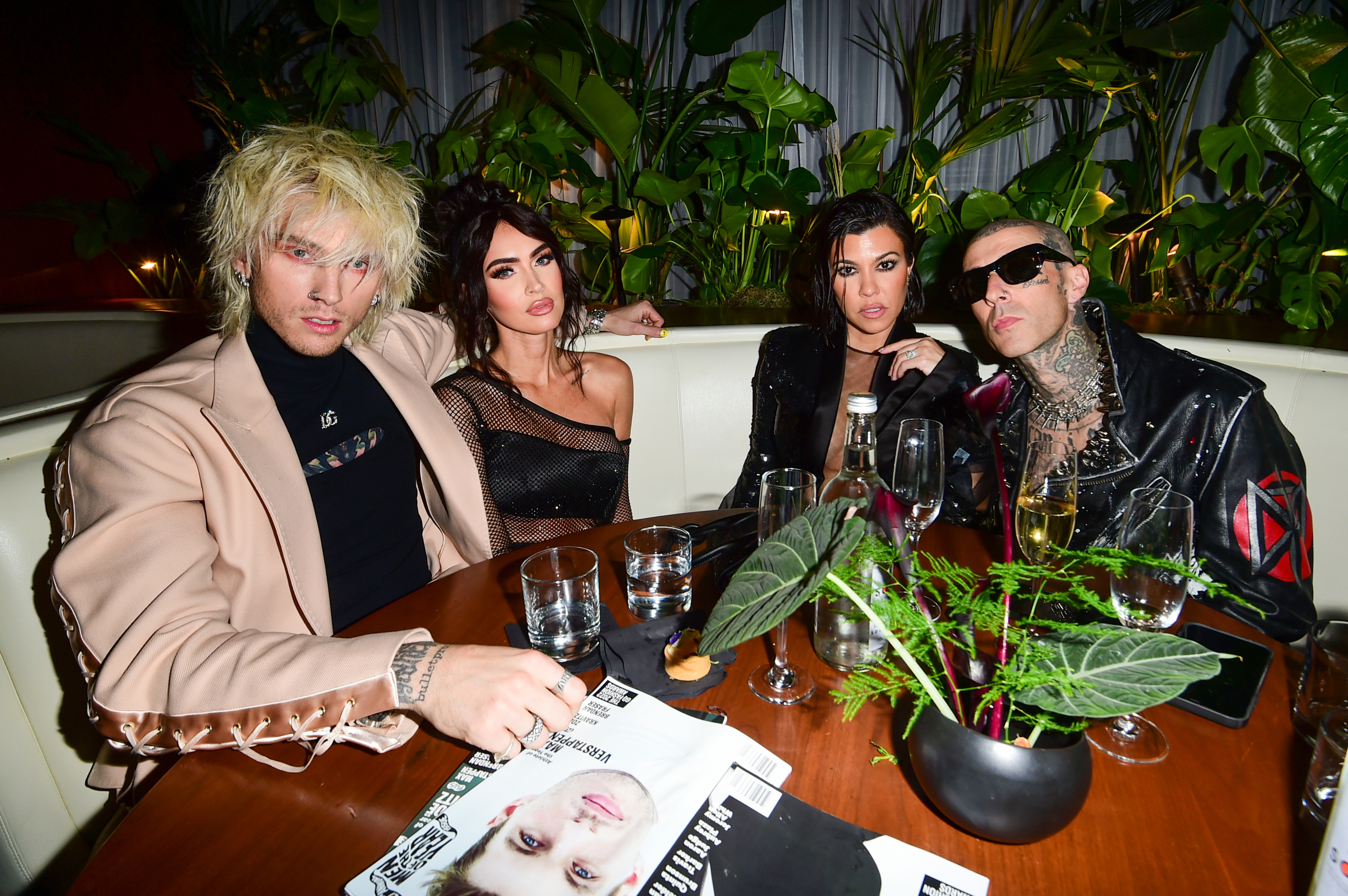 Kourtney and Travis seated at a table with MGK and Megan Fox