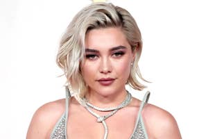 Florence Pugh smiling softly while wearing a sparkly dress
