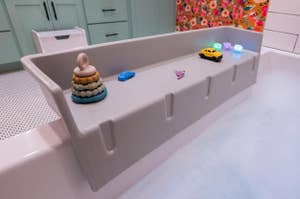 A bathtub filled with bubbles, featuring floating toys on the edge, in a bathroom setting for a shopping article