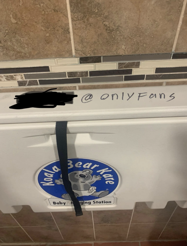 Changing station with an &quot;OnlyFans&quot; sticker, a blacked-out username, and a Koala Kare logo