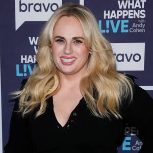Rebel Wilson poses in a black dress at an event