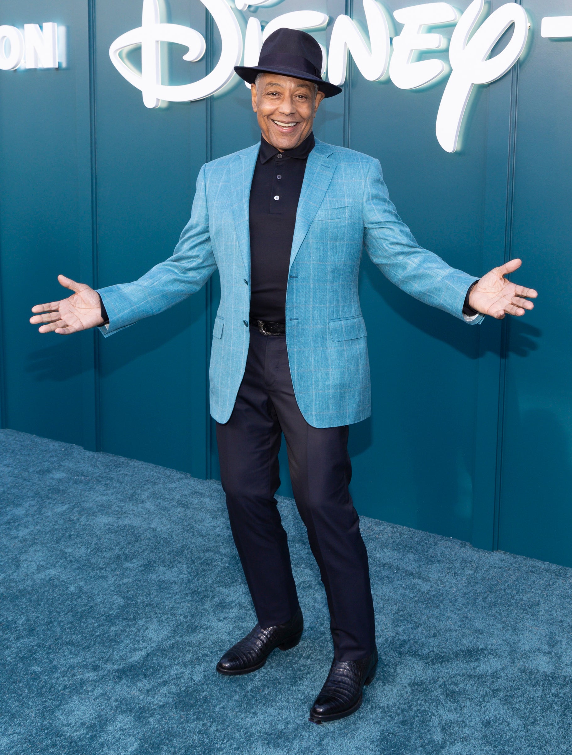 Giancarlo Esposito posing at a media event with his arms open