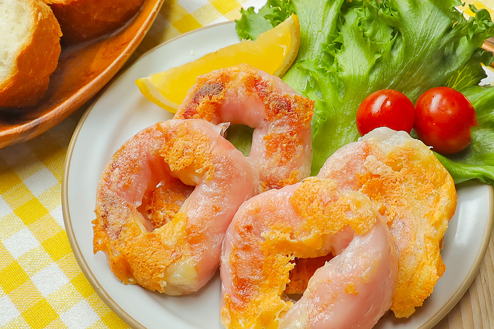 料理されたエビと野菜のサラダ、パンが添えられた食事の写真です。