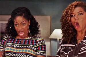 Two women expressing surprise, with one in a geometric pattern top, on a TV show set (Tiffany Haddish and Queen Latifah, as seen in the movie "Girls Trip")