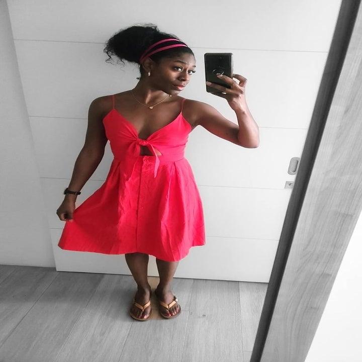 reviewer in a sleeveless knee-length dress posing for a mirror selfie