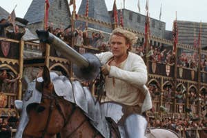 Heath Ledger in medieval attire with a lance on horseback at a jousting event, crowd in background