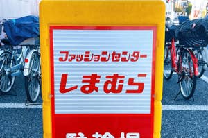 Sign in Japanese language on a stand; bicycles parked in the background