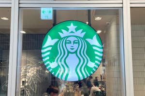 Starbucks logo displayed on the exterior of a store with customers inside