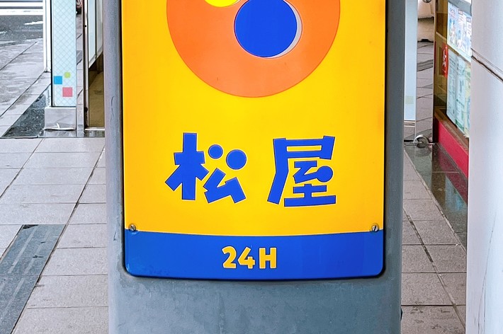 駐車場を示す標識。人と車のマークと「駐車」という文字、下に24Hの表示がある。